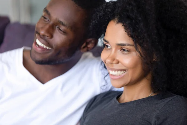 Close up happy African American couple sitting together on sofa — Stock Photo, Image