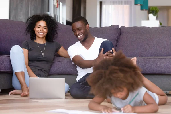 Afro-americano casado pareja usando portátil mientras hija jugando — Foto de Stock