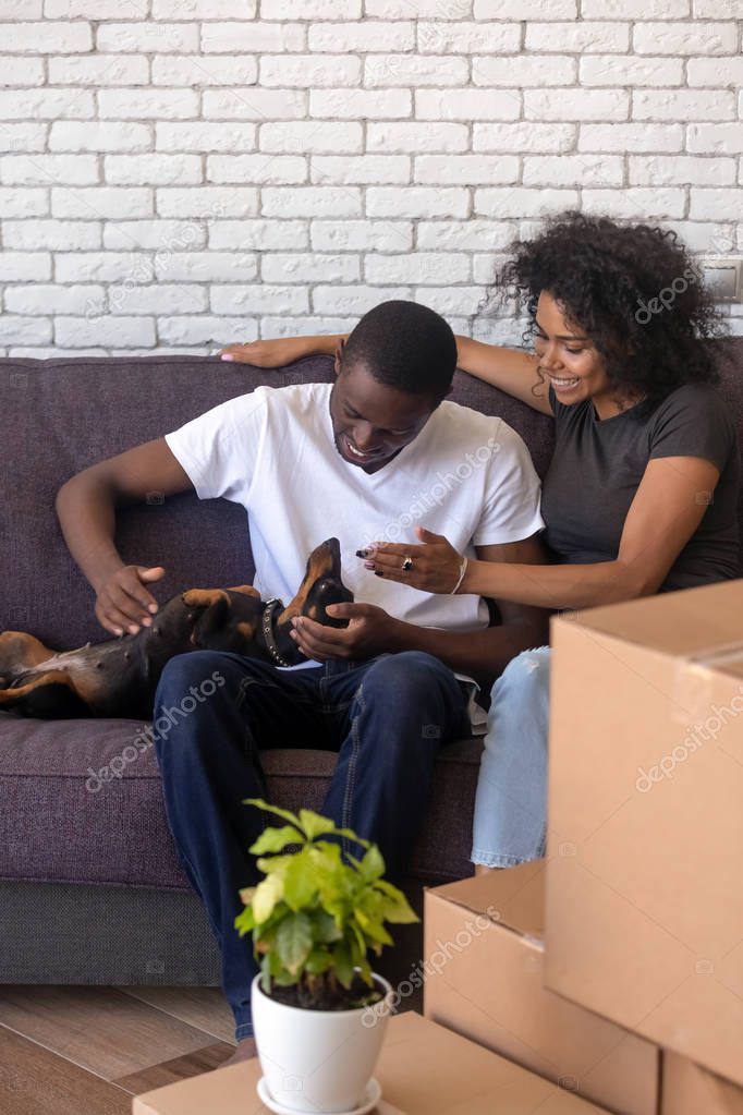 Happy African American couple with dog just moving in new house