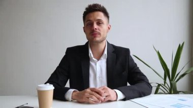 Takım elbiseli işadamı web kamerası konferans araması yaparken bakarak konuşuyor