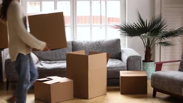 Щаслива пара розслабляється з картонними коробками, що рухаються в новому будинку — стокове відео