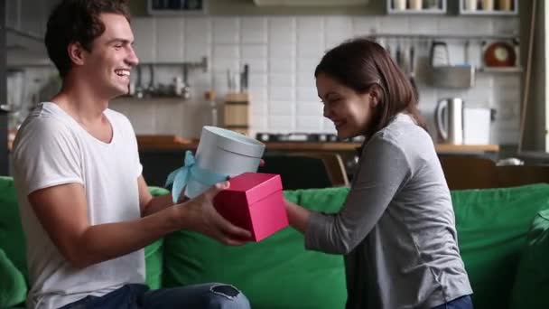 Excited happy young couple exchanging gifts on holiday at home — Stock Video