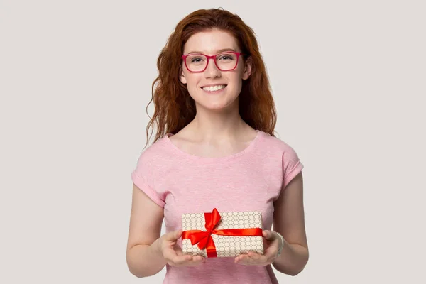 Sorridente ragazza dai capelli rossi fare regalo in possesso di scatola regalo — Foto Stock