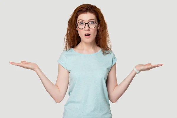 Puzzled redhead girl in glasses make choice comparing offers — Stock Photo, Image