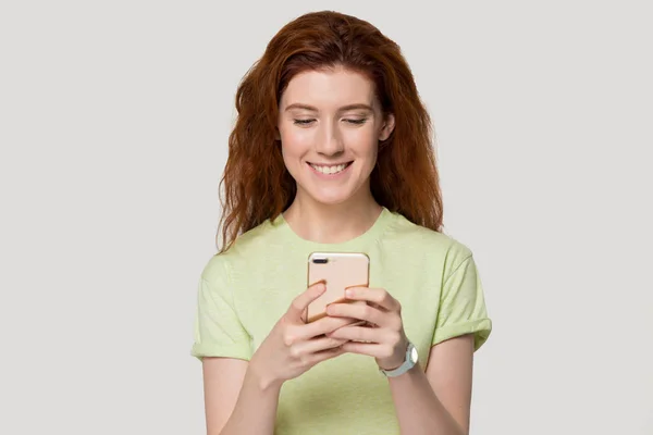 Leende rödhårig flicka glad få trevligt meddelande på smartphone — Stockfoto