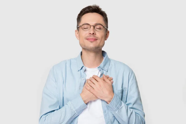 Grateful Caucasian man in glasses isolated on grey background — Stock Photo, Image