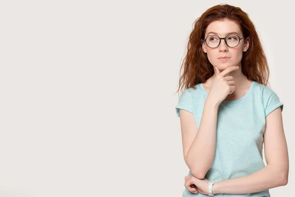 Pensativo pelirroja chica en gafas pensar en trato —  Fotos de Stock