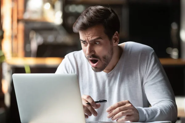 Homem chocado com a boca aberta olhando para a tela do computador — Fotografia de Stock