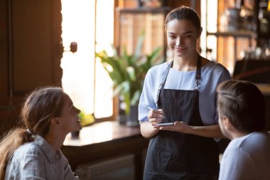 Evli bir çifte hizmet eden gülümseyen garson sipariş almak