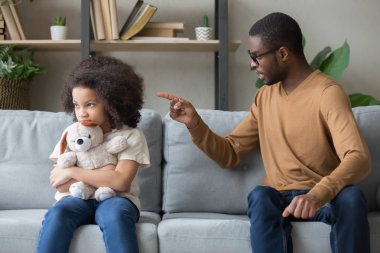 Afrikalı baba kanepede oturan disiplin inatçı kızı için azarlama