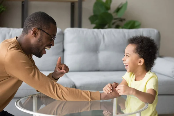 Père noir riant jouer avec un petit enfant à la maison — Photo