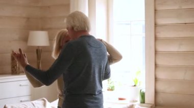 Mutlu üst düzey romantik çift modern ev oturma odasında dans