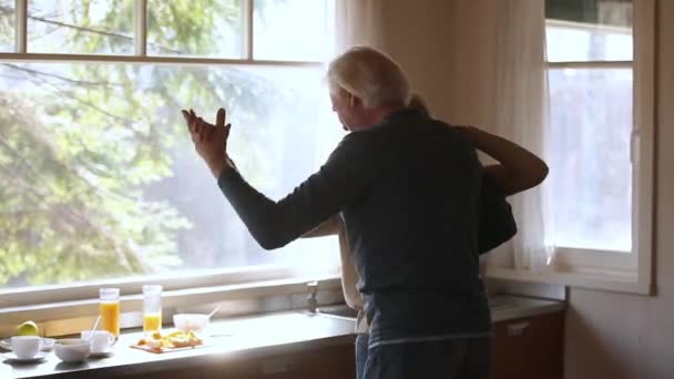 Mutlu olgun yaşlı çift mutfakta gülerek dans — Stok video