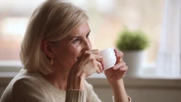 Dromerige gelukkige middelbare leeftijd vrouw op zoek weg drinken ochtend koffie — Stockvideo