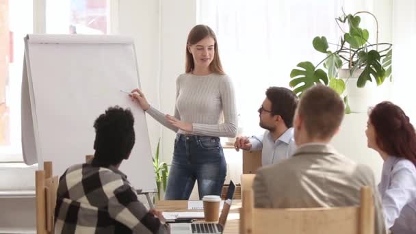 Treinadora de negócios dando apresentação no flipchart em reunião de grupo diversificada — Vídeo de Stock