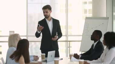 Takım elbiseli erkek çalıştırıcı çalışanlarla etkileşim de konuşurken sorular soruyor