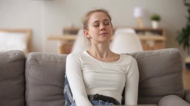 Sakin kadın kanepede oturarak evde temiz hava soludu