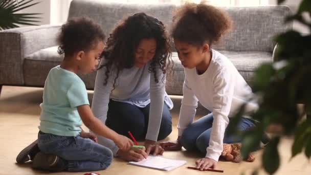 Gondoskodó afrikai anya rajz színes ceruza játszik a gyerekekkel — Stock videók