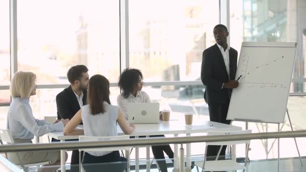 Treinador orador Africano dando apresentação no flipchart explicando gráfico financeiro — Vídeo de Stock