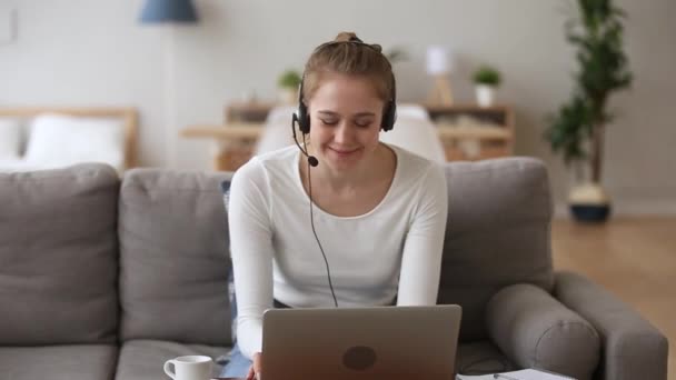 Menina feliz no fone de ouvido falando por webcam olhando para laptop — Vídeo de Stock