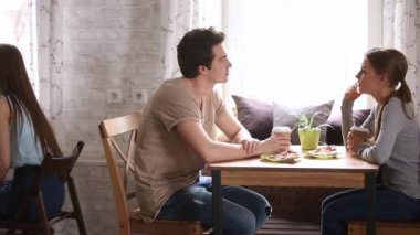 Kafelerde kahve içen masalarda oturan çok ırklı insanlar