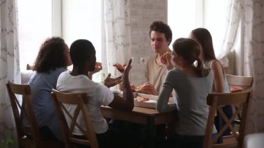 Mutlu multiracial genç arkadaşlar pizza paylaşım kafe masa yeme konuşurken