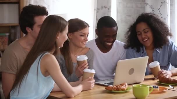 Gelukkig jonge gevarieerde vrienden met plezier kijken komedie op laptop — Stockvideo