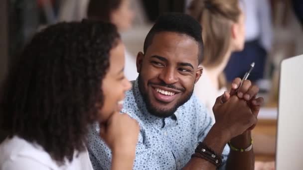 Sorrindo masculino Africano empregado ouvindo mulher colega sentado no escritório — Vídeo de Stock