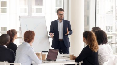 Takım elbiseli erkek iş koçu hoparlör flipchart sunum vermek