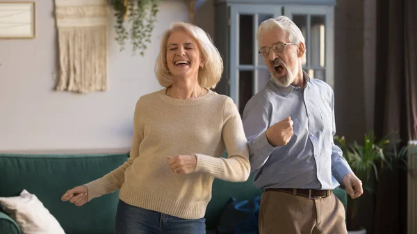 Aufgeregtes reifes Paar, Mann und Frau haben Spaß, tanzen zusammen — Stockfoto
