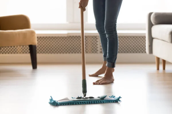 Крупный план босиком девушка делает уборку дома с помощью мокрой швабры — стоковое фото