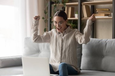 Heyecanlı kadın online kazanmak kutluyor bilgisayar ekranına bakarak