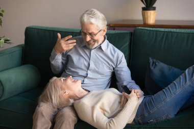 Gülümseyen olgun karısı koca dizlerinin üzerinde yatan, evde rahatlatıcı