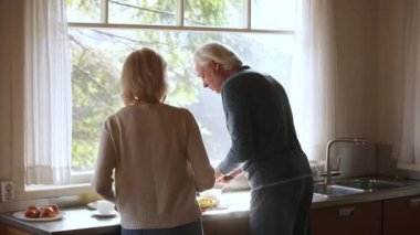 Arka görüş olgun çift birlikte yemek ve mutfakta dans