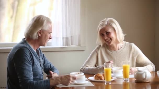 Ancianos atractiva pareja comiendo sano desayuno riendo se siente feliz — Vídeo de stock