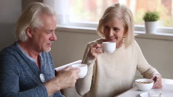 Пожилые супруги с приятным разговором пьют утренний кофе дома — стоковое видео