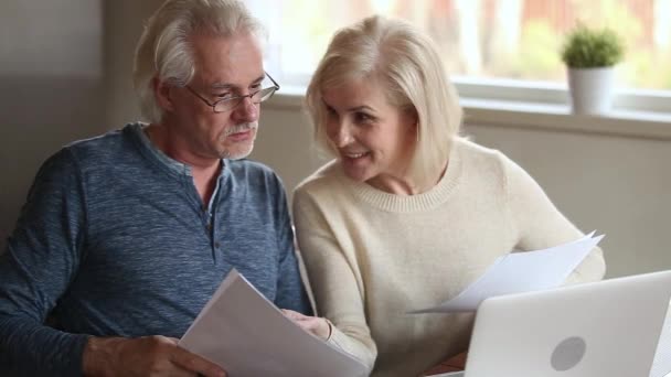 Elderly satisfied spouses holding bills makes easy online payments — Stock Video