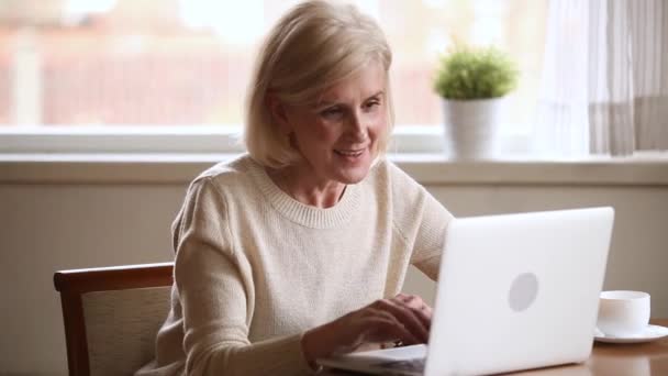 Літня жінка використовує комп'ютерний зв'язок онлайн з дорослими дітьми — стокове відео