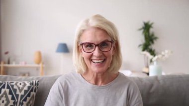 Yaşlı kadın kamera bakarak görüntülü arama yapma gülerek konuşurken