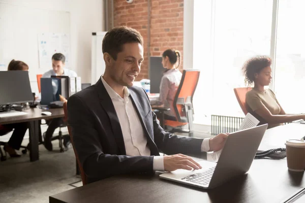 Sorrindo trabalho empregado masculino com documento no laptop — Fotografia de Stock