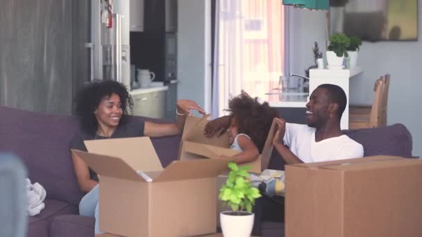 Menina criança feliz pular para fora da caixa jogar com pais negros — Vídeo de Stock