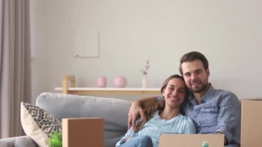 Hareketli günde oynayan kanepede çocuk kucaklayan gülümseyen anne