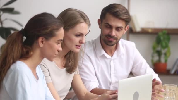 Los empleados enfocados trabajan juntos en grupo utilizando una computadora portátil que colabora en la oficina — Vídeos de Stock