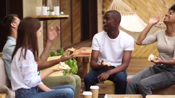 Amigos felices multiculturales riendo comiendo pizza en restaurante al aire libre — Vídeos de Stock