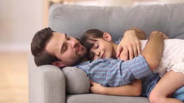 Gelukkige vader liggend op sofa knuffelen Kid rest knuffelen samen — Stockvideo