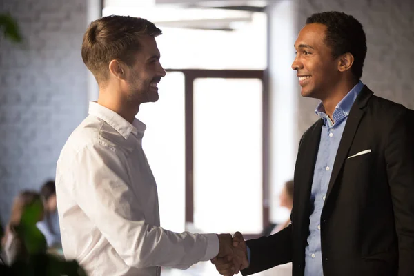 Side view black and caucasian businessmen shaking hands — Stock Photo, Image