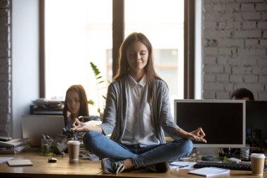 Odaklanmış ofis çalışanı masada oturan ve meditasyon