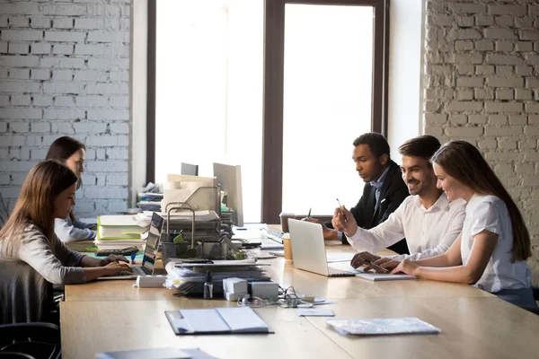 Cinco compañeros de trabajo multirraciales que tienen una jornada laboral ocupada en la sala de coworking — Foto de Stock