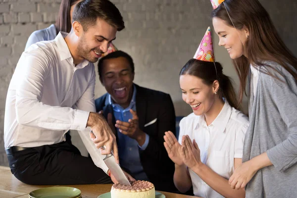 Geburtstagskind mit Messer schneidet von Kollegen geschenkten Kuchen an — Stockfoto