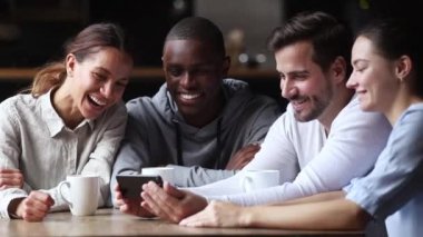 Mutlu çeşitli arkadaşları akıllı telefonda komik video izlerken eğlenmek